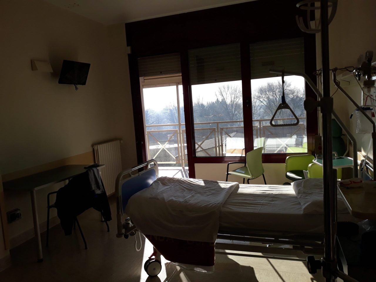 Stanza di degenza del Policlinico G.B. Rossi con televisore e porta finestra sul parco